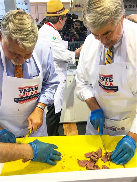 USDA Under Secretary of Agriculture for Trade and Foreign Agricultural Affairs Ted McKinney (right) and Paul Malik, U.S. consul general in Dubai, slice U.S. beef at the Taste of the USA pavilion at Gulfood 2018